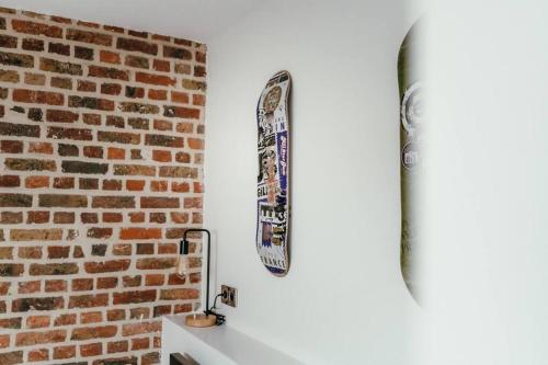 un skateboard accroché à un mur à côté d'un mur de briques dans l'établissement Duplex 4pers - 100m du métro - SmartTV - Fibre, à Lille
