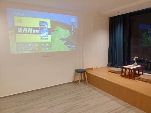 a lecture room with a projection screen and two chairs at Huang Mountain Wangfeng Hotel in Huangshan Scenic Area