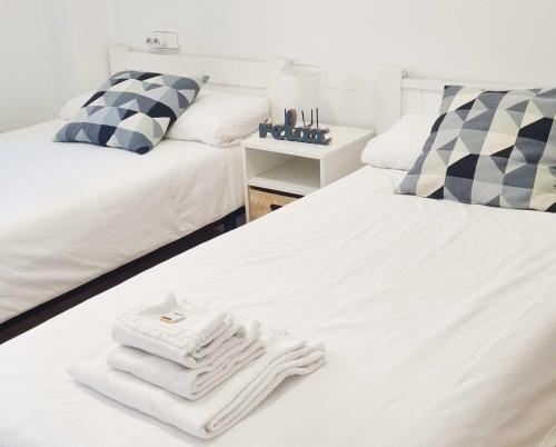 a room with two beds with white towels on them at Arboleda Centro in Soria