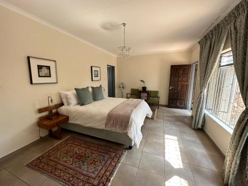 a bedroom with a bed and a large window at Beynespoort Farm in Cullinan