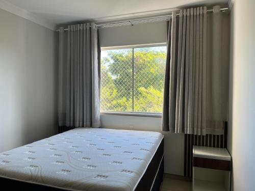a bedroom with a bed and a window at Águas da Serra Apart hotel in Rio Quente