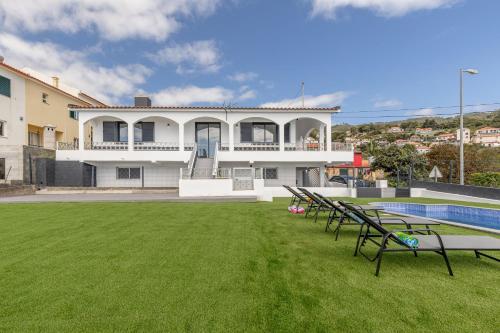 a large house with a swimming pool and a yard at Maylily Seascape Villa in Santa Cruz