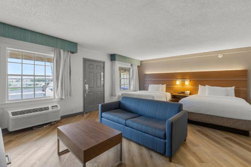 Habitación de hotel con 2 camas y sofá azul en La Quinta Inn by Wyndham Phoenix Thomas Road en Phoenix