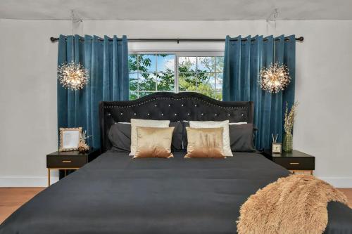 a bedroom with a large bed with blue curtains at Director's Cut - A Birdy Vacation Rental in San Antonio