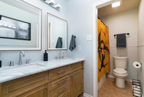 a bathroom with a sink and a toilet and a mirror at Bunker Down - A Birdy Vacation Rental in San Antonio