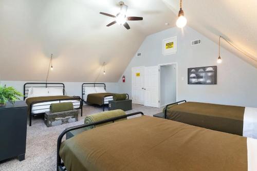 a room with three beds and a ceiling fan at Bunker Down - A Birdy Vacation Rental in San Antonio