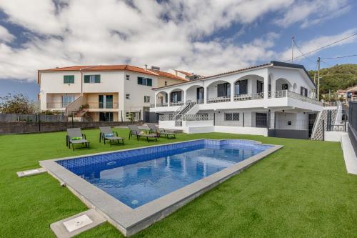 a house with a large yard with a swimming pool at Maylily Seascape Villa in Santa Cruz
