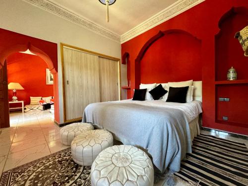 a bedroom with a large bed with red walls at Jenny Lynn in Marrakech