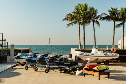 a group of boats parked on a beach with palm trees at A Concept Hotel & Spa in Búzios
