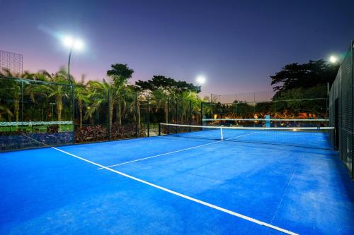 a tennis court with a net on it at night at Zendaya Resort Beach Sport & Spa in Búzios
