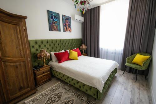 um quarto com uma cama com almofadas vermelhas e amarelas em Metelitsa Hotel em Karaganda