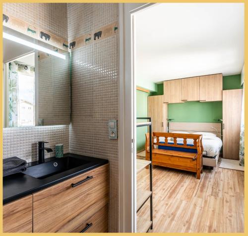 ein Badezimmer mit einem Waschbecken und ein Schlafzimmer mit einem Bett in der Unterkunft T3 / Lumineux / Annemasse in Annemasse