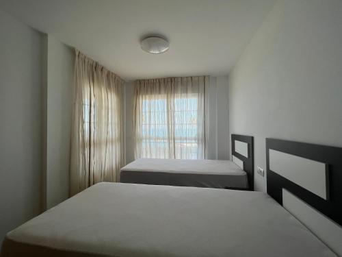 a bedroom with two beds and a window at Torreon del Mar in Benalmádena