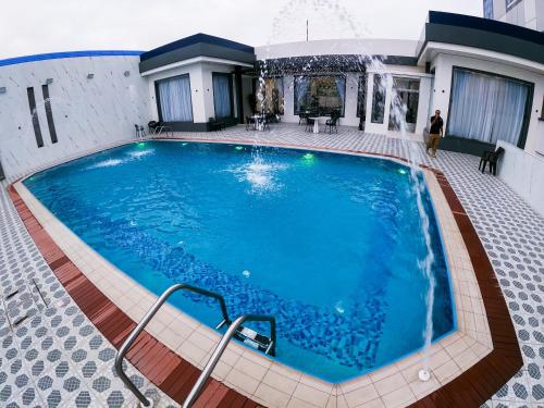 a large swimming pool in the middle of a building at Nesto Hotel in Manāwirah