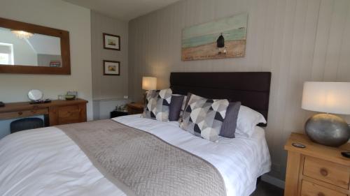 a bedroom with a bed and a mirror at Plas Tan y Graig B&B Guest House Beddgelert in Beddgelert