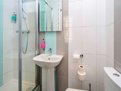 a white bathroom with a sink and a shower at stay in in New Delhi
