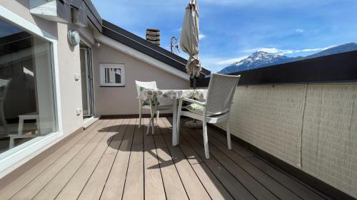 a balcony with a table and chairs on a roof at Casa Lilla LT in Gravedona