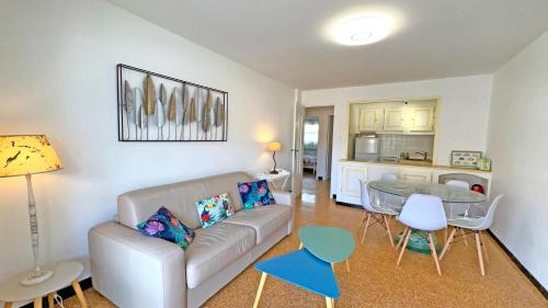 un salon avec un canapé et une table dans l'établissement Le Neptune, à Sainte-Maxime