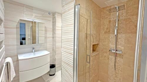 Un baño con lavabo y ducha en Le Neptune, en Sainte-Maxime