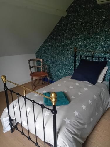 a bedroom with a black and white bed and a chair at Bois d'Yevre in Vierzon