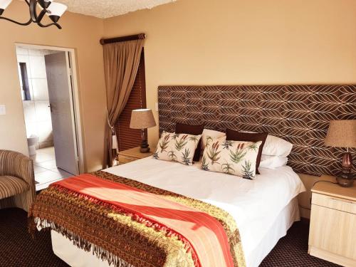 a bedroom with a large bed with a large headboard at Crystal Lagoon Lodge in Langebaan