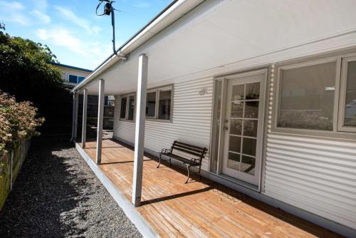 a wooden deck with a bench on a house at Nautique in Metung