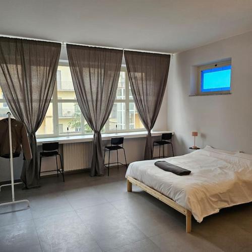 Un dormitorio con una cama y una ventana grande. en La Casetta, en Alba