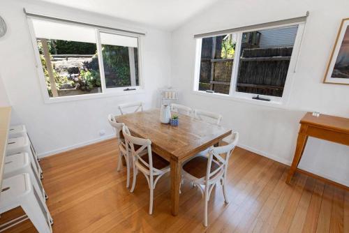 a dining room with a wooden table and chairs at Nautique in Metung