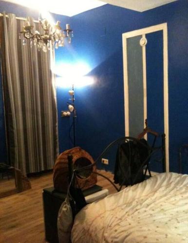 ein Schlafzimmer mit einem Bett und einer blauen Wand in der Unterkunft 2 pièces 40m2 au bord du lac à Breil sur Roya in Breil-sur-Roya