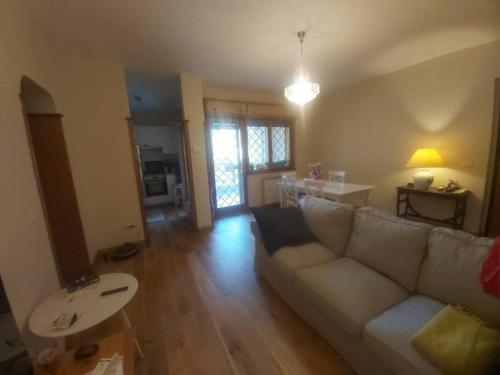 Una sala de estar con un sofá blanco y una mesa. en Casa Mauli, en Settebagni