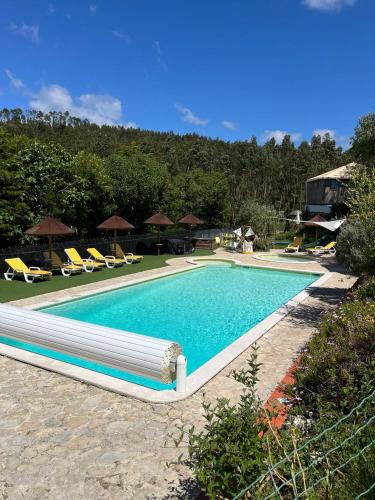 a swimming pool with blue water in a resort at Quinta Laranja - Turismo Rural - in Alvorninha