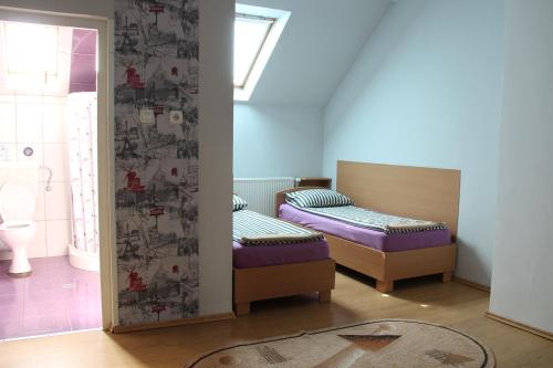 Zimmer mit 2 Betten und einem Bad in der Unterkunft SZÁSZ&SZÁSZ PANZIÓ in Gheorgheni