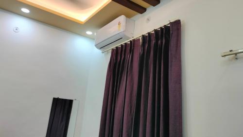 Habitación con cortina y TV. en Hotel Kashyaam Inn en Varanasi