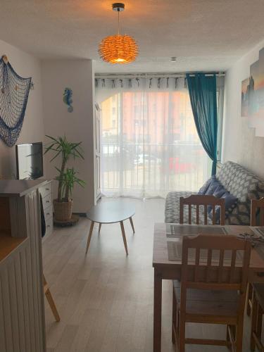 un salon avec un canapé et une table dans l'établissement Joli studio proche plage du Môle, au Cap d'Agde
