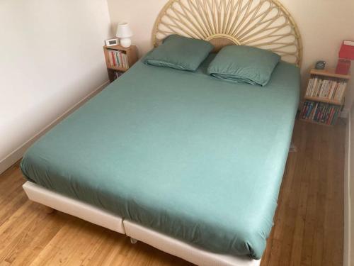 uma cama grande com uma cabeceira em madeira num quarto em Grande maison à 5 minutes des plages em La Rochelle