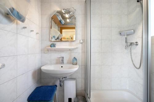 a white bathroom with a sink and a shower at Ferienwohnung Kilian in Oersberg