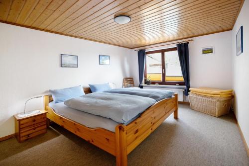a bedroom with a large bed with a wooden ceiling at Ferienwohnung Kilian in Oersberg