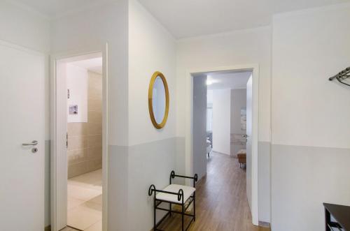 a white hallway with a chair and a mirror at Opashus in Borkum