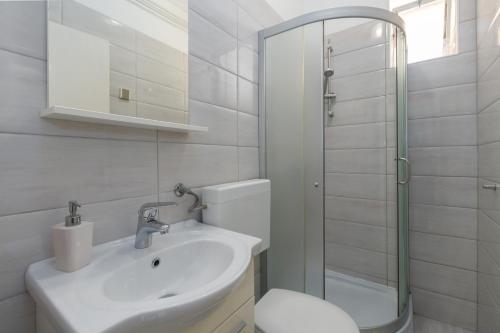 uma casa de banho com um lavatório, um WC e um chuveiro em Silvia big private garden em Funtana