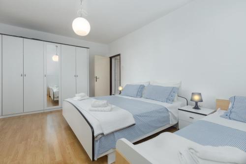 um quarto branco com 2 camas e um espelho em Silvia big private garden em Funtana