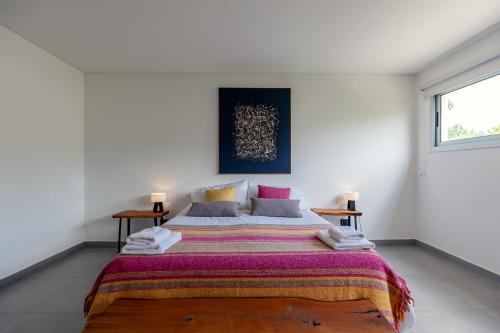 ein Schlafzimmer mit einem großen Bett mit einer bunten Decke in der Unterkunft The Acacia Village in Ciudad Lujan de Cuyo