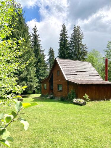 a wooden cabin in the middle of a green yard at Pin chalet in Borzont
