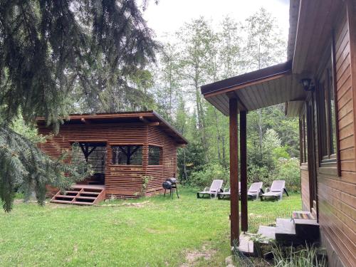 a log cabin with chairs and a grill in a yard at Pin chalet in Borzont