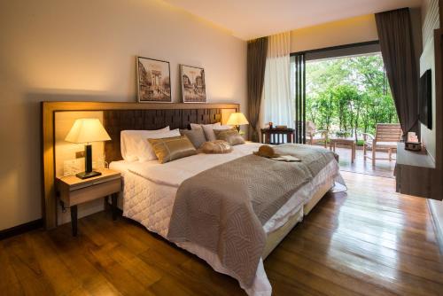 เตียงในห้องที่ Rimnaam Klangchan Hotel - SHA Plus