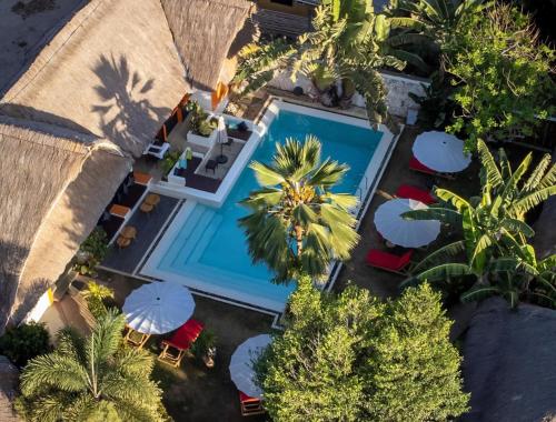 an overhead view of a swimming pool with palm trees and umbrellas at Villa Kasadya in Panglao
