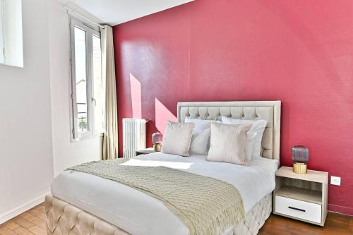 a bedroom with a pink wall and a bed at Appartement Rose Moderne Proche de la capitale in Gagny