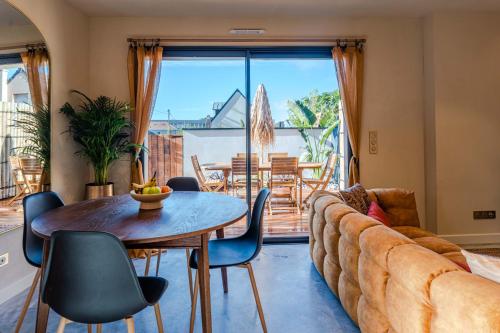 un salon avec un canapé, une table et des chaises dans l'établissement Nénuphar, à Caen