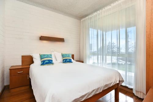 sypialnia z łóżkiem i dużym oknem w obiekcie Dolphins Beachfront Apartment No 4 w mieście Port Elliot