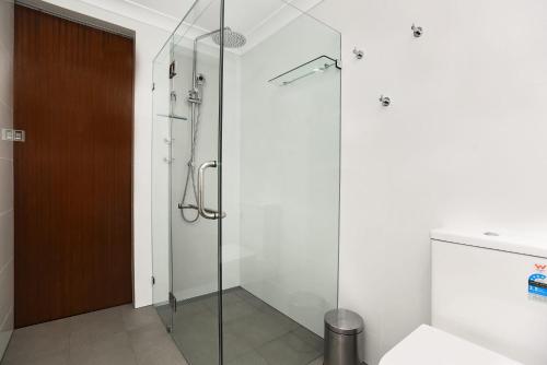 W łazience znajduje się prysznic ze szklanymi drzwiami. w obiekcie Dolphins Beachfront Apartment No 4 w mieście Port Elliot