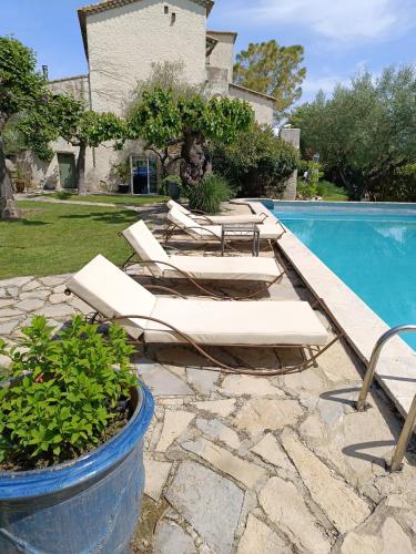 - un groupe de chaises longues à côté de la piscine dans l'établissement La Capitelle , Chambre double indépendante avec piscine, à Deaux